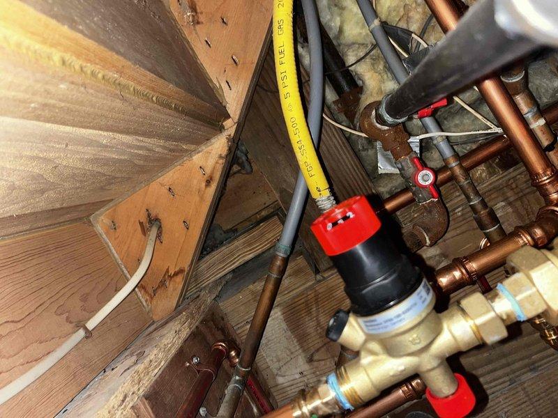 Responded to warranty service call for no heat condition. Inspected plumbing system with focus on backflow preventer assembly and associated copper piping. Examined gas line connections and multiple shut-off valves throughout the system. Verified proper installation of pressure regulator and control valves, ensuring all components were functioning correctly to restore heating operation.