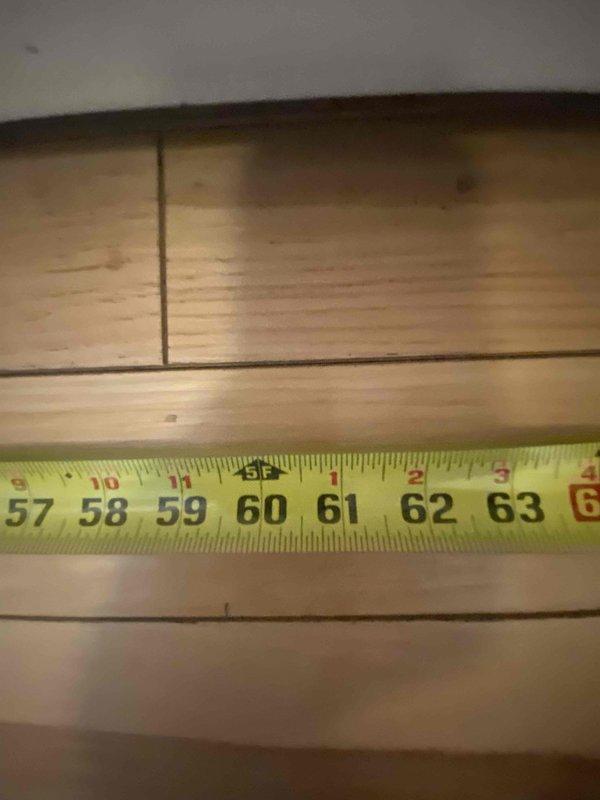 Conducted assessment for radiator relocation and replacement project in basement utility area. Took measurements of existing piping and floor space to determine feasibility of moving kitchen drain and water line for refrigerator DZ. Documentation includes photographs of utility room setup and precise measurements of installation area.