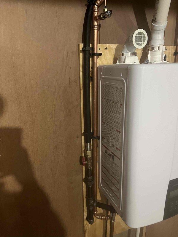 Responded to service call for leaking 75-gallon gas power-vented water heater. Upon inspection, confirmed active leak from tank requiring immediate replacement. Drained existing unit and removed from service. Installed new tankless gas water heater system with proper venting, including PVC exhaust piping and intake air supply. Connected copper supply lines with shutoff valves, verified all gas connections for safety, and tested unit operation. System commissioned and confirmed proper hot water delivery throughout property.