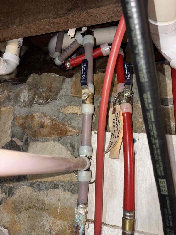 Responded to a non-functional exterior water spigot that could not be turned on or off at a 125-year-old remodeled residence. Upon inspection, isolated the issue to the outdoor spigot fixture requiring replacement. Accessed the plumbing distribution system through the MANABLOC manifold panel, which controls multiple PEX supply lines throughout the home. Shut off the appropriate hot and cold water supply valves at the manifold to isolate the exterior spigot line. Traced the red PEX supply line from the manifold to the exterior wall penetration point. Removed the failed outdoor spigot assembly and inspected the connection point for any additional damage or deterioration. Installed a new frost-free outdoor spigot with proper sealing at the wall penetration to prevent water intrusion. Verified all PEX connections at the manifold remained secure with proper insulation coverage on exposed supply lines. Restored water supply at the manifold and tested the new spigot for proper operation, conf