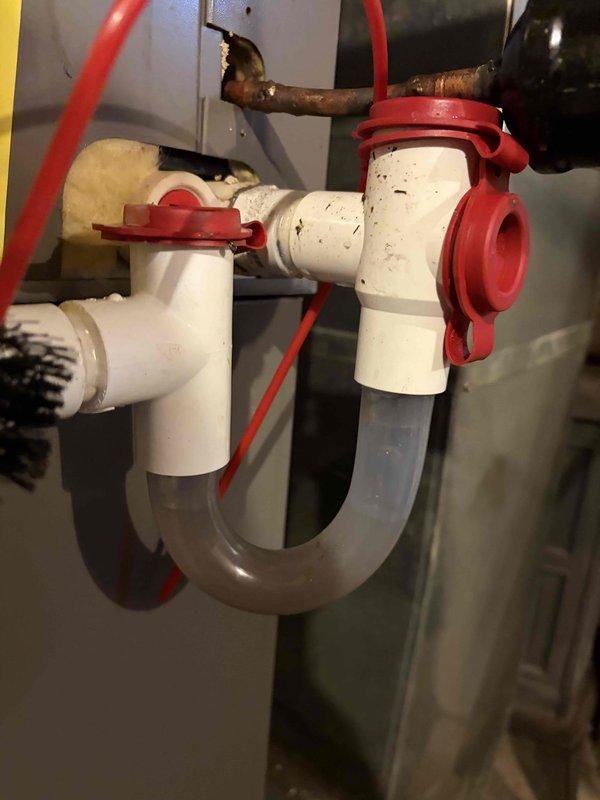 Completed cooling maintenance club visit on residential HVAC system. Performed electrical diagnostics using multimeter, measuring 244.1 VAC at the unit, confirming proper voltage supply to the system. Inspected condensate drain assembly including P-trap, PVC drainage lines, and safety float switch with red shut-off valve, all found to be functioning properly with no blockages detected.