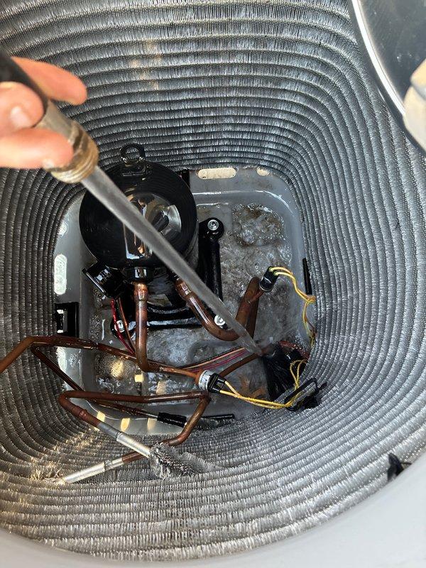 Completed cooling maintenance club visit at residential property. Performed comprehensive inspection of HVAC system including indoor air handler unit and outdoor condensing unit. Inspected furnace/air handler assembly, verified proper operation of hot water heater connections, and examined PVC condensate drain lines with visible shutoff valves. Conducted detailed examination of outdoor heat pump unit with housing removed, inspecting compressor assembly, refrigerant line connections, and copper tubing for signs of wear or damage. Noted moisture accumulation and minor discoloration on condenser base pan beneath compressor. Verified electrical connections and wiring integrity throughout system. All components operating within normal parameters upon completion of maintenance inspection.