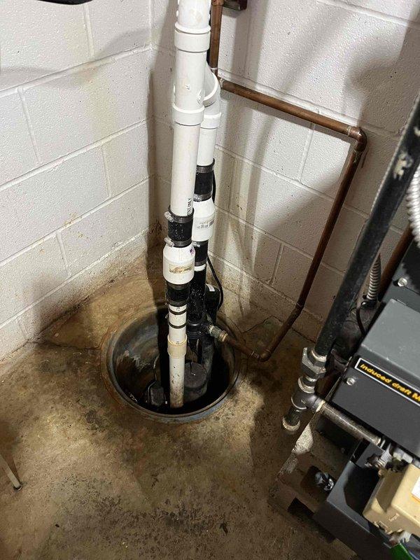 Replaced water-driven sump pump system with battery backup unit in basement utility area. Removed existing discharge piping and installed new PVC discharge line with proper securing to wall. System tested and verified operational with backup power capability to ensure continued protection against basement flooding during power outages.