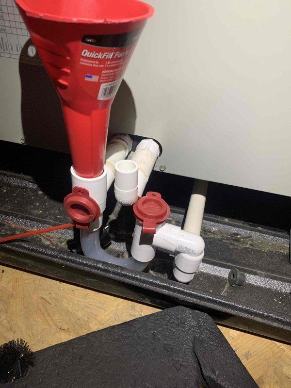 Completed cooling maintenance club visit on air handler system. Inspected condensate drain assembly with QuickFil funnel and PVC piping configuration, verifying proper drainage function and checking for blockages or leaks. Performed electrical diagnostics using Fieldpiece SC480 multimeter, measuring amperage draw at 0.70A and voltage readings to verify system performance within manufacturer specifications. All components operating normally with no issues identified during inspection.