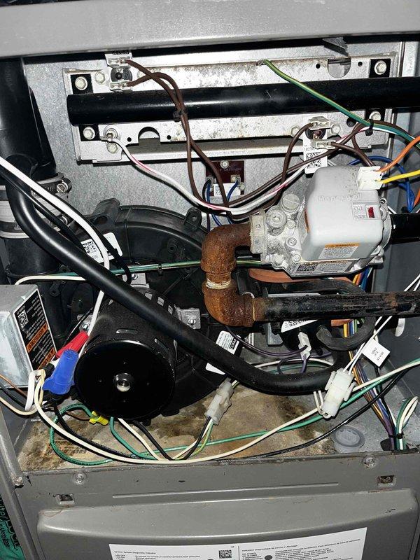 Completed cooling maintenance club visit on air handler system. Performed comprehensive inspection of HVAC components including ductwork, refrigerant lines, compressor unit, and blower motor assembly. Documented system condition with detailed photographs showing flexible ductwork installation in confined space and internal mechanical components. Noted copper refrigerant line elbow joint exhibiting rust and corrosion at 90-degree connection point requiring monitoring. Verified compressor unit wiring connections and terminals in proper condition. Inspected blower motor assembly and mounting hardware. Checked refrigerant line insulation and securing brackets. All maintenance tasks completed per club membership agreement specifications.