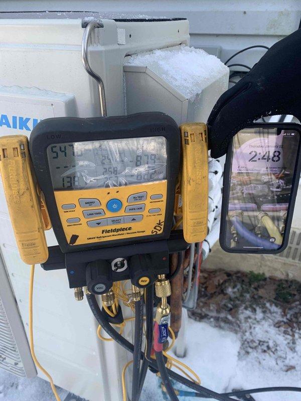 Returned to site with two technicians for comprehensive leak search on 4-head mini-split system under warranty conditions. System was previously charged with nitrogen and refrigerant mixture for leak detection purposes. Utilized digital manifold gauges to monitor system pressures and temperatures while conducting thorough inspection of outdoor unit, refrigerant line connections, and all four indoor head units. Performed methodical leak search procedures on all accessible components including line sets, service ports, and mechanical connections during favorable ambient conditions above 32°F, which allowed for proper refrigerant behavior and accurate leak detection.