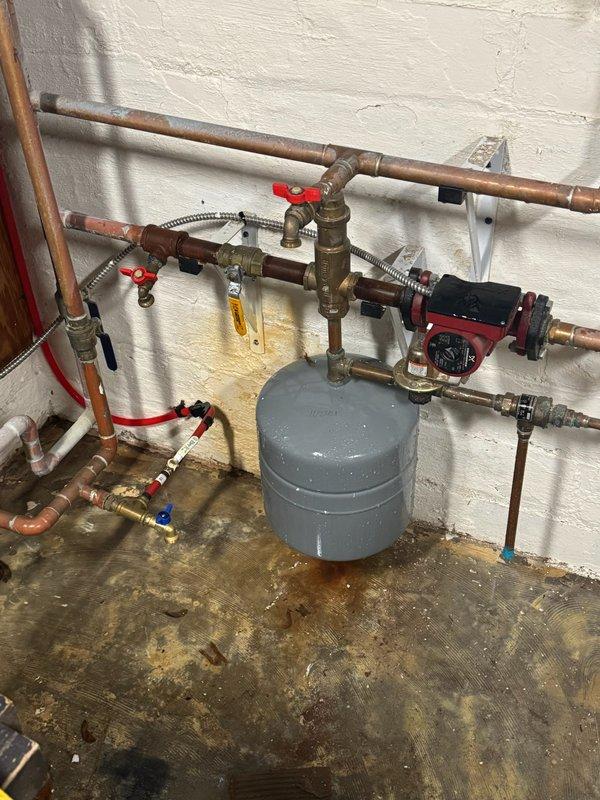 Responded to service call for ruptured expansion tank on five-year-old hot water heating boiler system. Replaced failed expansion tank with new unit, reconnected to system piping using appropriate brass fittings and isolation valves. Verified system pressurization, checked circulator pump operation, and confirmed proper heating function across all zones with no leaks detected at connections.