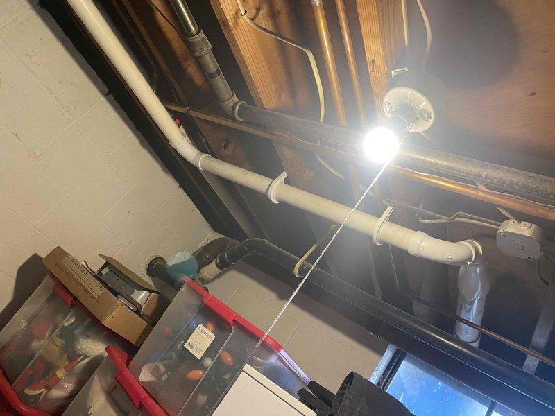 Completed installation of new wall-mounted boiler system with comprehensive hydronic piping network in basement mechanical room. Installed and configured primary heating unit with integrated manifold system featuring multiple copper supply and return lines, blue-handled isolation valves, and brass fittings for zone control. Mounted gray expansion tank and electrical control panel, ran flexible metal conduit for power supply, and completed all necessary plumbing connections including PVC venting routed through ceiling joists to exterior termination point.