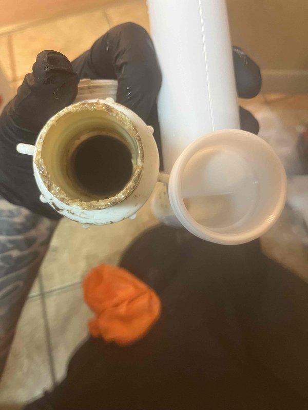 Returned to complete installation of 40-gallon water heater that was previously sold. Removed deteriorated PVC drain line showing significant mineral buildup and sediment accumulation on interior walls. Replaced compromised piping with new PVC components and verified proper combustion operation, with burner assembly displaying clean blue flame characteristics and appropriate heat distribution throughout the unit.
