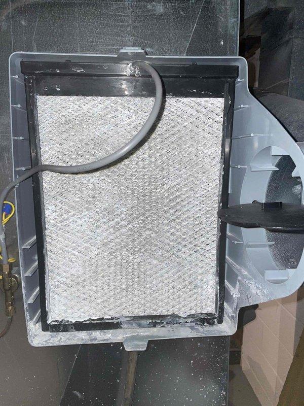 Completed heating maintenance club visit and addressed reported humidifier leak at air handler. Inspected humidifier assembly, removed and examined evaporator pad which showed mineral buildup and discoloration indicating active water flow issues. Used inspection camera to assess internal ductwork connections and mounting points for source of leak. Documented condition of humidifier pad assembly and drainage components with photos for service records.