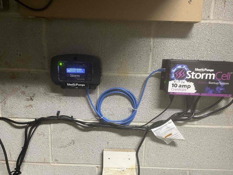 Responded to emergency basement flooding caused by failed primary sump pump in 20+ year old home. Upon inspection, found original sump pump inoperable and unable to discharge water from pit, resulting in active water accumulation on basement floor. Removed and replaced failed unit with new Liberty Pumps system. Installed complete StormCell Battery Backup System with 10-amp charger to provide redundant protection during power outages or primary pump failure. Mounted control panel and monitoring equipment to basement wall, including Storm digital display unit for real-time system status monitoring. Configured PVC discharge piping with proper vertical and horizontal routing to ensure adequate water removal. Connected backup battery unit and verified all electrical connections meet code requirements. Tested primary pump operation, float switch activation, and battery backup engagement to confirm full system functionality. System now provides dual-layer protection with continuous monitoring