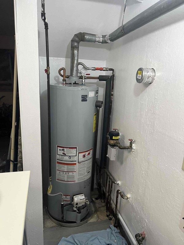 Conducted on-site evaluation of existing conventional tank-style gas water heater with atmospheric venting to provide estimate for tankless water heater conversion. Assessed current utility closet configuration, existing gas supply line capacity, venting infrastructure including PVC exhaust system, electrical requirements, and available clearances for tankless unit installation. Documented existing plumbing connections, copper supply lines, shut-off valves, and temperature controls to determine necessary modifications for tankless system integration.