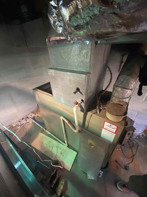 Completed HVAC estimate for replacement of flood-damaged Magic Chef oil furnace and existing air conditioning system in basement utility area. Equipment assessment confirmed both heating and cooling systems were compromised by water damage and required full replacement due to age and operational failure.