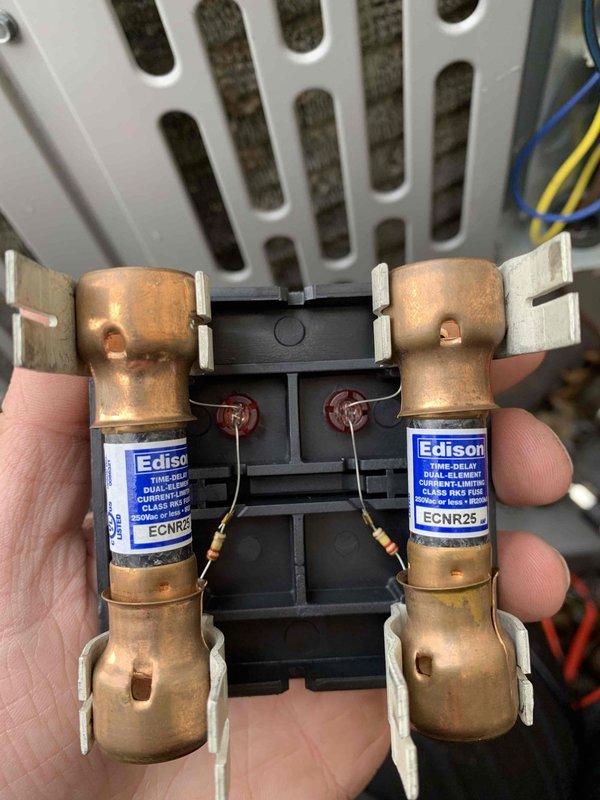 Completed cooling maintenance club visit on air handler unit. Inspected electrical components including dual Edison ECNR25 fuses in holder, verified proper connections and wiring integrity. Measured system amperage at 24.00 amps using clamp meter, confirming unit operating within normal parameters. All components functioning properly with no issues identified.