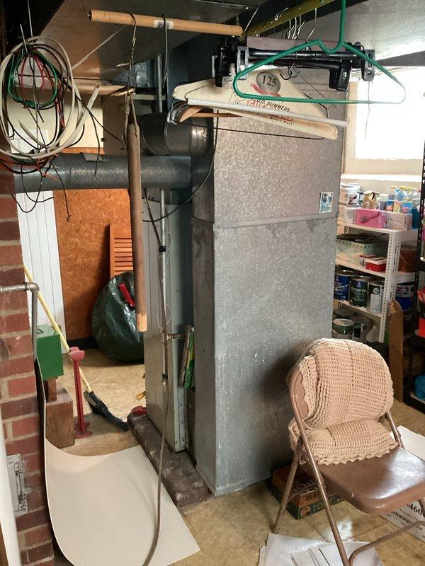 Conducted comprehensive HVAC system evaluation in basement utility area for equipment replacement estimate. Assessed existing furnace unit, ductwork configuration, and overall mechanical system layout. Documented current equipment condition, spatial constraints, and installation requirements including overhead ductwork connections, exposed brick wall proximity, and concrete floor mounting considerations for replacement system specifications.