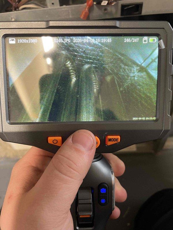 Responded to complaint of furnace blowing cold air. Performed diagnostic inspection using borescope camera to examine heat exchanger and internal ductwork components. Inspection revealed disconnected or improperly routed flexible duct connections within the system, preventing heated air from properly circulating through the supply plenum. Documented findings with inspection camera showing flexible ductwork and heat exchanger condition for service records.