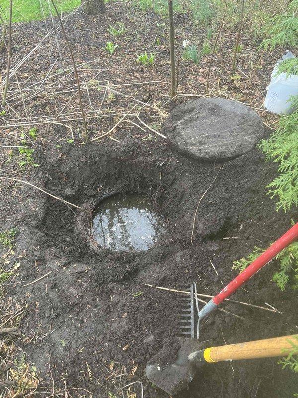 Responded to emergency call for sump pump alarm activation with water backup. Upon arrival, inspected sump pump basin and found pump mechanism submerged and non-operational. Removed debris and sediment from basin interior that had accumulated around pump housing. Tested pump motor function and verified electrical connections were secure. Identified exterior discharge line issue with water pooling at termination point. Excavated discharge area to expose piping and corrected drainage slope to ensure proper water flow away from foundation. Cleared blockage from discharge line and repositioned outlet pipe. Backfilled excavation site and restored grade. Tested complete system operation by running pump through multiple cycles to confirm proper water evacuation and alarm reset. System restored to full functionality with no further backup issues detected.