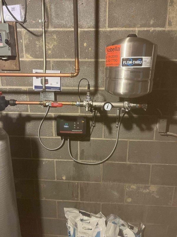 Returned to property to replace a failed circulator pump under manufacturer warranty. Removed the defective Grundfos X series pump and control unit from the hydronic heating system and installed a new replacement unit. Connected the new pump to the existing copper piping, expansion tank assembly, and electrical conduit. Verified proper operation of the digital control panel, pressure gauge readings, and system flow. Tested all connections for leaks and confirmed the heating system was functioning correctly with the new pump operational.