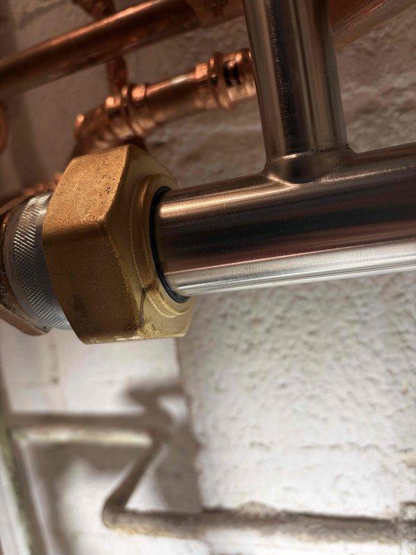 Responded to callback for leaking boiler installed previous week. Upon arrival, inspected all water connections and fittings on newly installed unit. Located source of leak at brass compression fitting on copper supply line. Fitting had loosened due to thermal expansion during initial system operation. Tightened compression nut to proper torque specification using appropriate wrench. Pressurized system and monitored all connections for 15 minutes with no further leakage detected. Verified proper boiler operation and left system running normally.