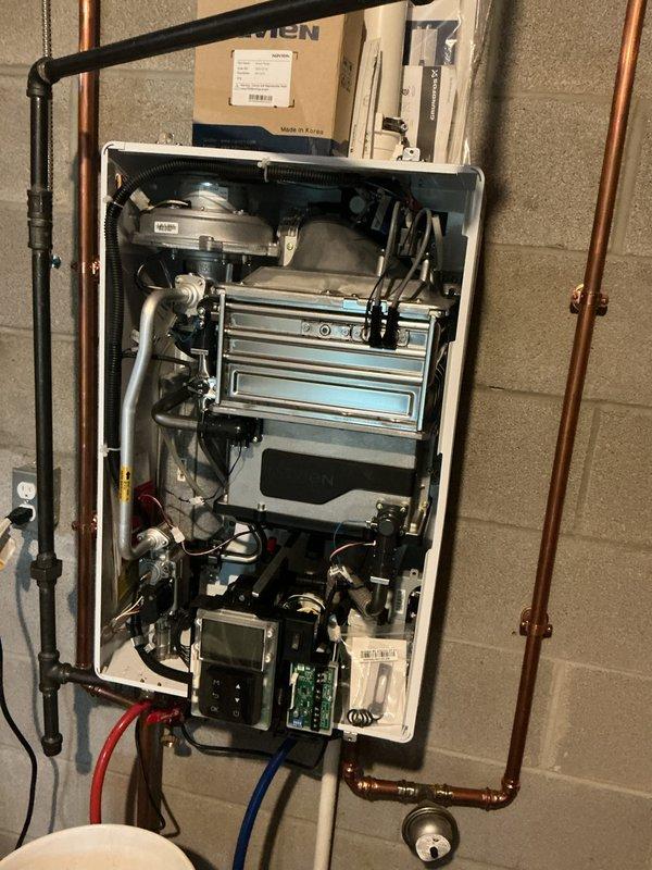 Responded to no hot water complaint on wall-mounted tankless water heater unit. Removed front cover and performed diagnostic testing using digital monitoring equipment to assess internal components and heat exchanger functionality. Conducted post-purge system evaluation and inspected copper piping connections, isolation valves, and internal circuitry including control board. Verified proper installation of supply and return lines with shut-off valves. Completed troubleshooting procedures and restored hot water service to the residence.