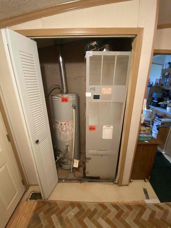 Completed HVAC system evaluation for replacement estimate at residential property with 28-year-old furnace and 4-5 year-old air conditioning system located in utility closet. Documented existing equipment configuration including aging furnace unit with visible wear, operational water heater with proper venting, and newer AC condenser. Assessed closet space dimensions, clearances, and existing ductwork connections to determine replacement equipment specifications and installation requirements for updated high-efficiency HVAC system.