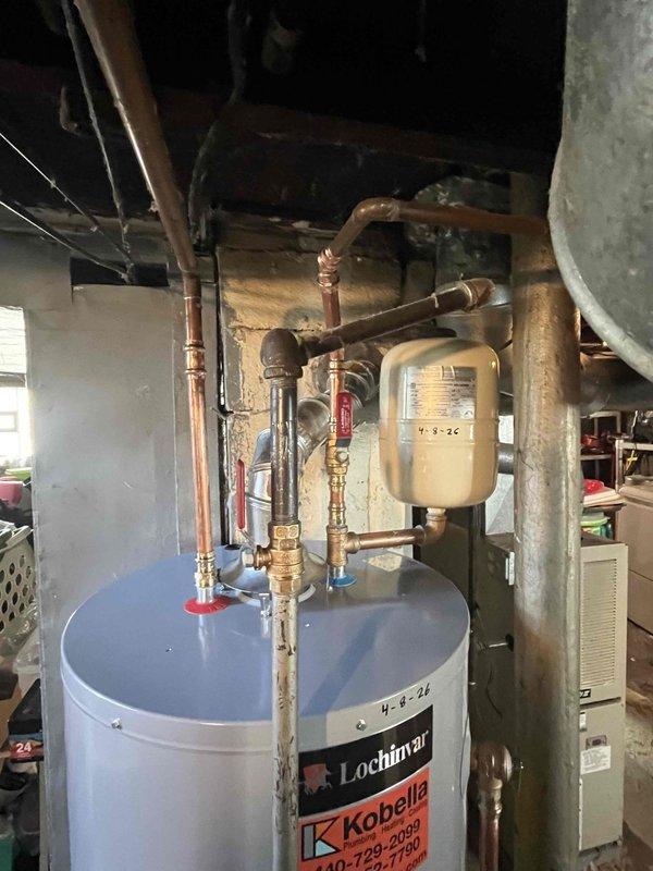 Responded to service call for leaking gas water heater requiring replacement. Upon inspection, confirmed active leak from existing unit, a Lochinvar brand tank-style gas water heater showing signs of age and deterioration. Based on installation space constraints and customer requirements, determined need for short-style 40-gallon gas water heater replacement.

Documented existing installation configuration including gas control valve assembly with Resideo controller, copper supply and distribution piping, expansion tank mounted to overhead joists, and connection to gas supply line with shutoff valve. Photographed gas control settings, thermocouple connections, and overall mechanical room layout showing integration with HVAC system and plumbing infrastructure.

Assessed installation requirements for replacement unit to match existing footprint and clearance specifications in basement utility area. Verified gas supply compatibility and existing venting configuration to ensure proper repl