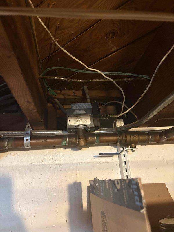 Responded to transferred boiler estimate inquiry. Conducted thorough assessment of existing hydronic heating system, focusing on zone valve assembly and associated copper distribution piping. Documented current system configuration including motorized zone valve mounted to horizontal copper supply lines in basement mechanical space. Valve actuator and brass body connections showed signs of age with visible patina on copper piping. Verified electrical connections to zone valve motor and assessed overall condition of heating distribution infrastructure. Captured detailed photographs of valve assembly, mounting configuration, and wiring for estimate preparation purposes.