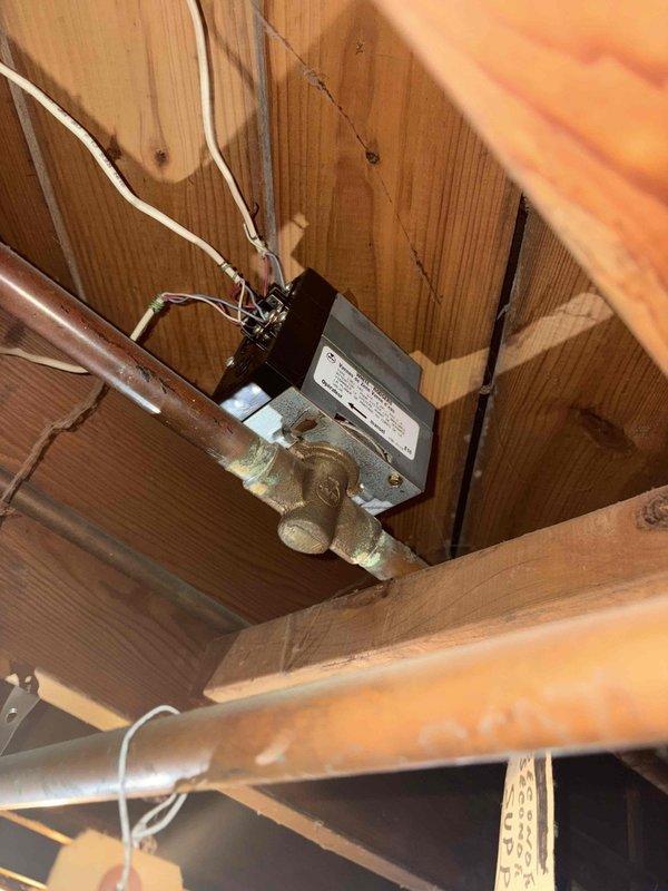 Responded to transferred boiler estimate inquiry. Conducted thorough assessment of existing hydronic heating system, focusing on zone valve assembly and associated copper distribution piping. Documented current system configuration including motorized zone valve mounted to horizontal copper supply lines in basement mechanical space. Valve actuator and brass body connections showed signs of age with visible patina on copper piping. Verified electrical connections to zone valve motor and assessed overall condition of heating distribution infrastructure. Captured detailed photographs of valve assembly, mounting configuration, and wiring for estimate preparation purposes.