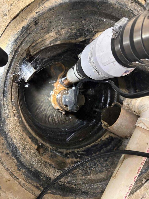 Performed comprehensive maintenance service on dual sump pump system including primary and secondary pumps. Inspected both sump basins, which showed signs of sediment accumulation and discolored water indicating extended operational use. Evaluated pump mechanisms for corrosion and mineral buildup on metal components, noting visible deterioration on float assemblies and discharge piping. Serviced battery backup system to ensure emergency operation capability during power outages. Verified proper discharge pipe connections and electrical cord routing within both basins.