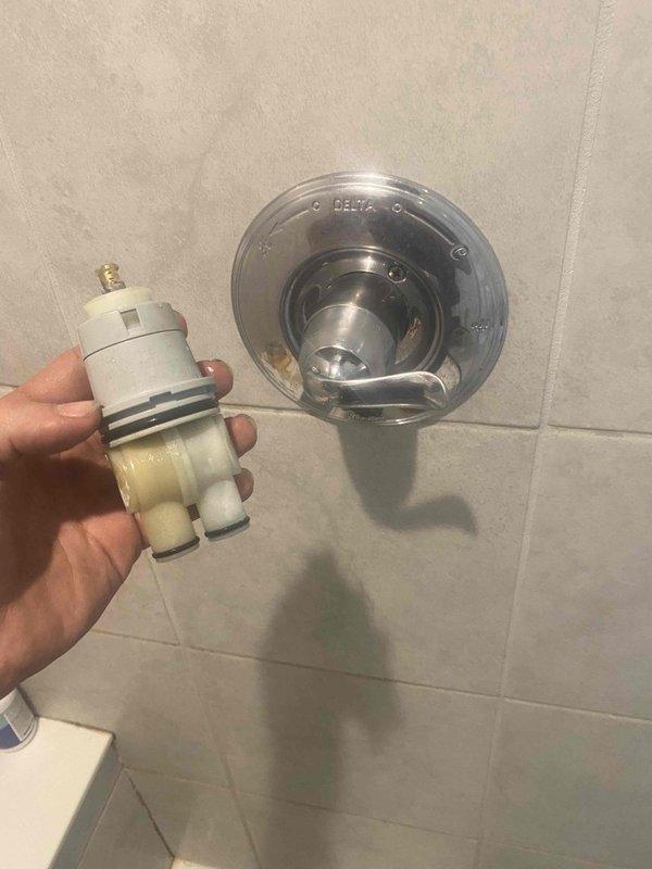Completed return service to install previously sold Delta multi-turn shower cartridge. Removed existing worn cartridge showing significant mineral buildup and debris accumulation in valve body, thoroughly cleaned valve housing and seating surfaces, and installed new Delta replacement cartridge with fresh O-rings. Tested operation of temperature control and water flow, verified proper handle function, and confirmed no leaks at trim plate assembly.