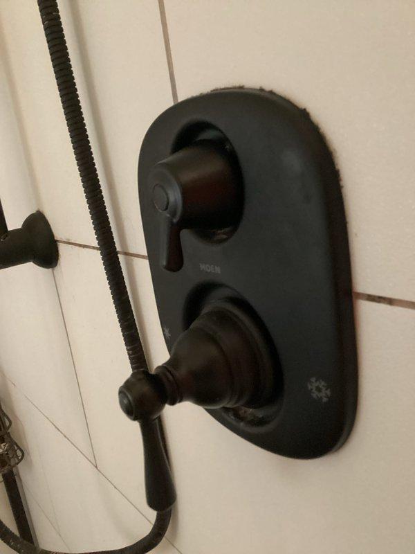 Completed plumbing membership inspection and maintenance visit. Evaluated shower valve assembly with dual control handles and handheld shower attachment, checking for proper operation and potential leaks. Inspected accessible plumbing fixtures and storage areas for any signs of water damage, moisture intrusion, or plumbing concerns requiring attention.
