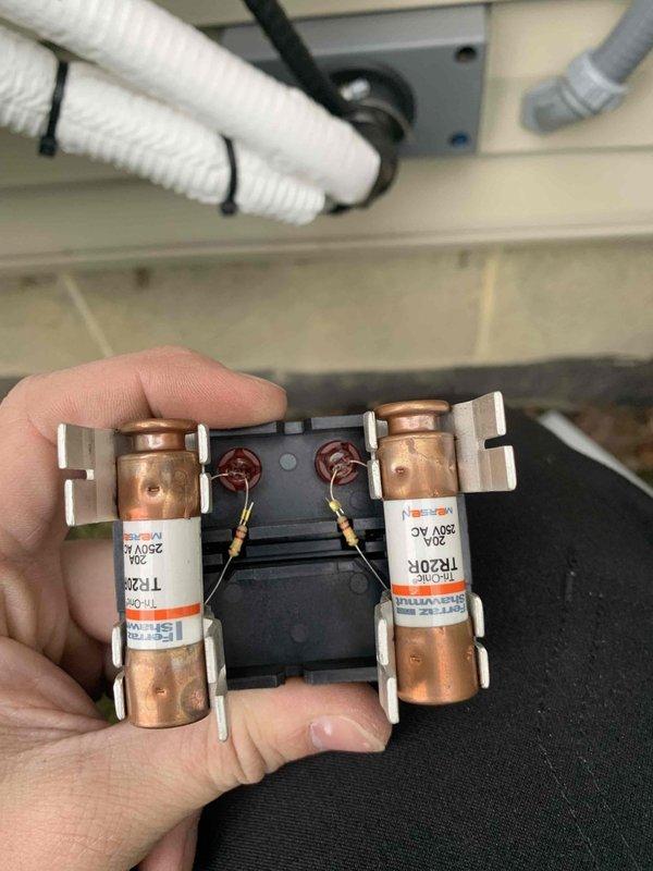 Completed heating maintenance club visit for ductless minisplit system. Performed electrical diagnostics using multimeter, verifying voltage readings at 775V AC and checking system operation. Inspected and documented fuse assembly showing dual 250V AC rated fuses in good working condition with proper wire connections intact.
