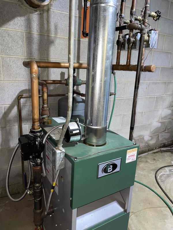 Completed scheduled boiler maintenance member visit on residential heating system. Performed comprehensive inspection of boiler unit, circulation pump, copper piping connections, and associated control systems. Verified proper operation of all safety controls including low water cutoff and system monitoring indicators, confirmed all green status lights illuminated correctly on control panel. Inspected flue pipe installation, valve operation, and overall system functionality with no issues identified.
