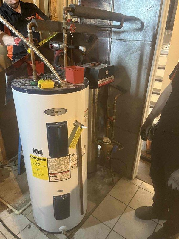 Installed 50-gallon electric Whirlpool water heater in residential utility space. Removed previously bypassed water softener from plumbing system, cut out associated piping, and re-routed water supply lines to accommodate new water heater installation. Connected all supply and discharge piping, installed expansion tank, configured temperature and pressure relief valve, and verified proper electrical connections and operational functionality upon completion.