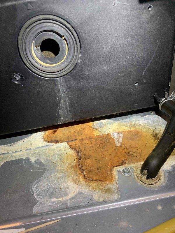 Responded to no-heat call for furnace system. Upon inspection, diagnosed failed inducer motor preventing unit operation. Observed significant rust and corrosion in condensate collection pan indicating moisture accumulation and drainage issues. Performed electrical testing with multimeter to verify motor failure, confirming 3.48-amp draw inconsistent with normal operating parameters. Identified inducer motor assembly requiring replacement due to mechanical failure and associated rust damage to surrounding components from prolonged moisture exposure.