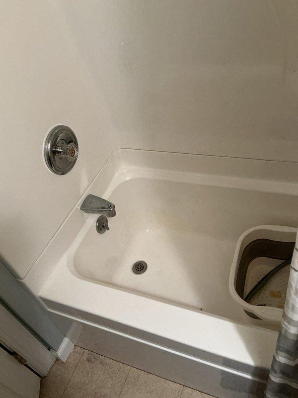 Completed routine plumbing membership inspection at residential property. Inspected bathroom fixtures including bathtub, shower controls, chrome spout, and drain assembly, confirming all components were functioning properly and in good condition. Examined exterior plumbing connections and utility access points on foundation for proper operation and noted no issues requiring immediate attention.