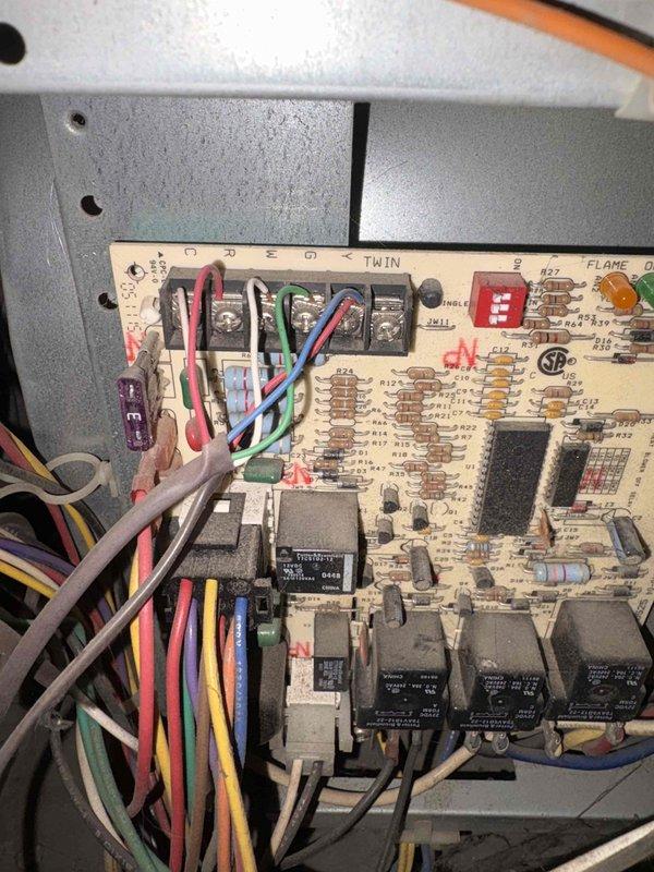 Completed HVAC estimate for air conditioning system replacement on property with 12-14 year old existing AC unit that has experienced operational issues. Customer elected to proceed with AC replacement at this time and defer furnace replacement for approximately one year, despite existing furnace also being 12-14 years old. Inspected current system configuration including furnace control board, ductwork, and equipment layout in basement mechanical room. Documented existing equipment conditions and provided replacement options for relocating outdoor condensing unit to preferred location. Photographed furnace circuit board showing control wiring, relays, and flame sensor components, as well as overall mechanical room setup with gas furnace, water heater, and duct distribution system.