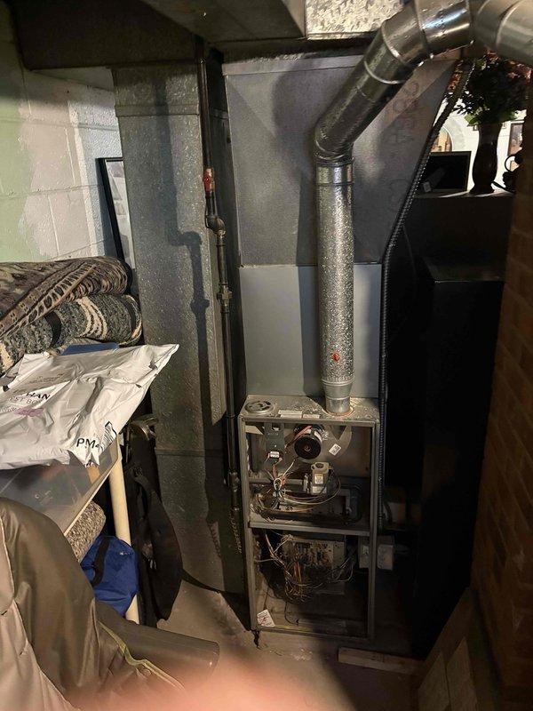 Completed HVAC estimate for air conditioning system replacement on property with 12-14 year old existing AC unit that has experienced operational issues. Customer elected to proceed with AC replacement at this time and defer furnace replacement for approximately one year, despite existing furnace also being 12-14 years old. Inspected current system configuration including furnace control board, ductwork, and equipment layout in basement mechanical room. Documented existing equipment conditions and provided replacement options for relocating outdoor condensing unit to preferred location. Photographed furnace circuit board showing control wiring, relays, and flame sensor components, as well as overall mechanical room setup with gas furnace, water heater, and duct distribution system.