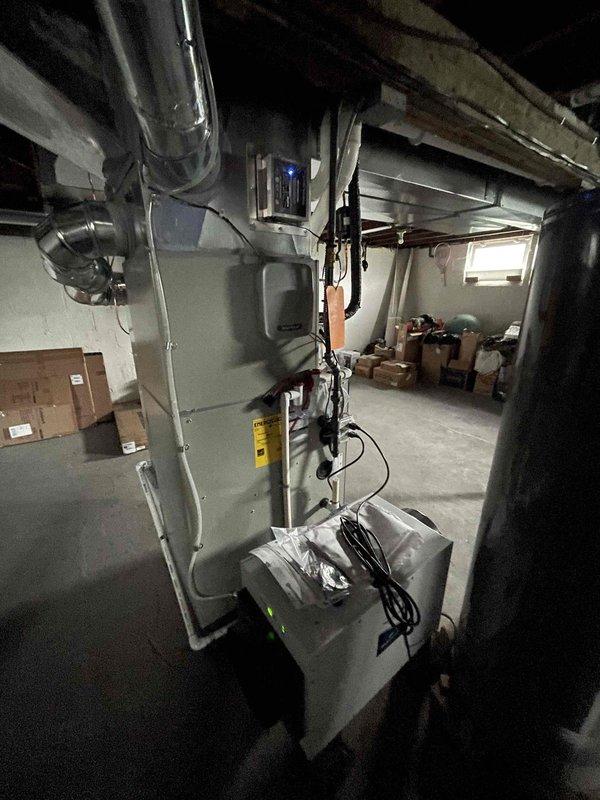 Responded to service call for delayed HVAC control panel responses and malfunctioning dehumidifier control buttons preventing humidity percentage adjustments. Inspected recently installed system (January 2026) including basement-mounted dehumidifier unit with green indicator lights and mesh filter, along with connected furnace/air handler unit with associated ductwork and control components. Documented equipment condition and control interface issues via photographs for warranty claim processing, as system remains within manufacturer warranty period.
