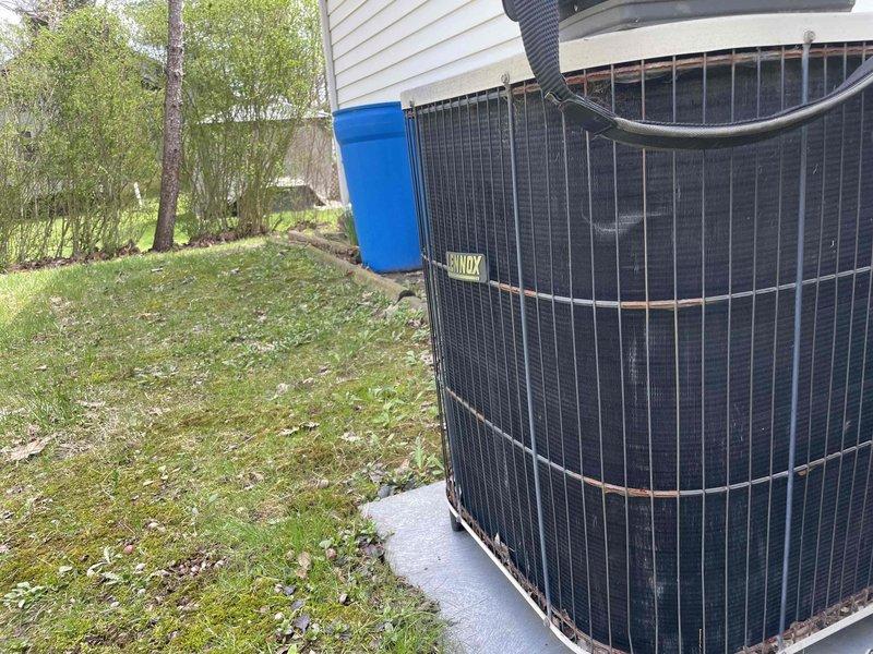 Completed cooling maintenance on residential HVAC system and identified potential thermostat malfunction requiring replacement at the air handler. Inspected outdoor condensing unit positioned on concrete pad and documented equipment condition, noting age-related wear and corrosion on metal components and weathered manufacturer labeling.