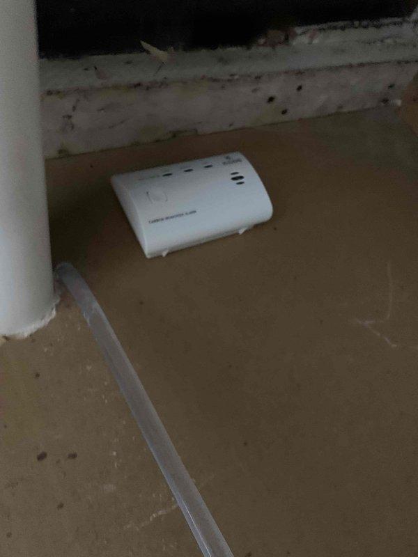 Responded to service call for cooling maintenance member reporting CO2 detector alarms during nighttime hours. Performed system inspection and documented condensate pump operation in utility area, verifying proper drainage function and equipment placement. Inspected carbon monoxide detection device on floor level, noted unit condition and surrounding area cleanliness for safety assessment.