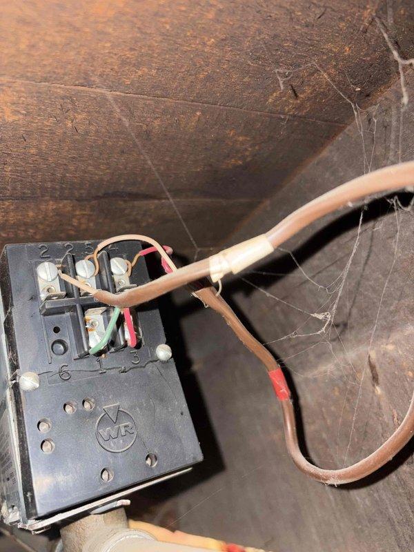 Responded to service call for persistent water leakage at boiler system. Identified leaking valve on water supply line feeding into boiler unit, which was discovered as a new issue following recent boiler repair work. Inspected system components, documented conditions with photographs of thermostat wiring configuration and electrical junction box in mechanical space, and assessed plumbing connections to determine source of water accumulation on floor. Leak isolated to feed line valve requiring replacement to resolve ongoing water discharge issue.