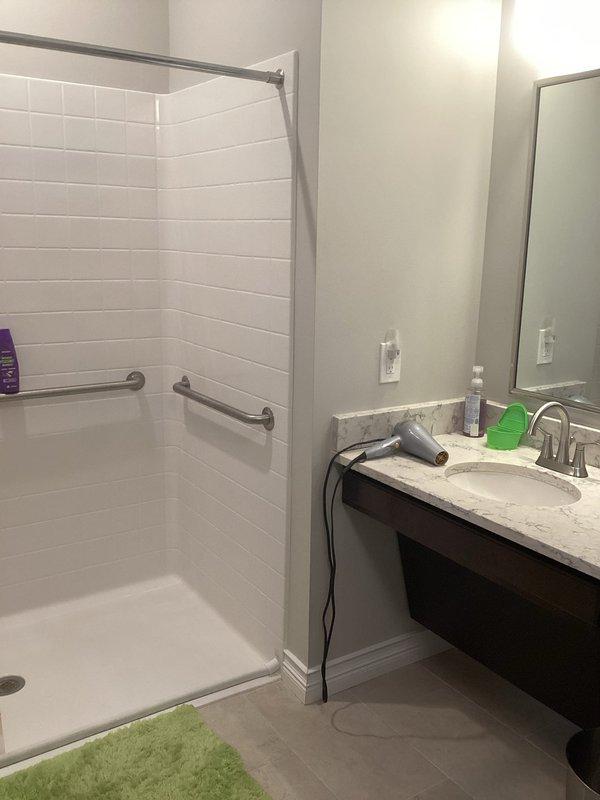 Responded to service call for frozen hot water shower lines that sustained damage over winter months. Conducted thorough assessment of accessible bathroom shower installation with white subway tile walls and dual grab bar safety features. Evaluated extent of freeze damage to hot water supply lines serving shower fixture with handheld chrome showerhead on adjustable sliding bar. 

Determined that proper winterization and insulation protection will require fiberglass wrap installation around vulnerable water lines. Assessment confirmed that scope of work necessitates partial disassembly of shower components to access supply lines behind tile walls. Project will involve careful removal and reinstallation of shower fixtures, potential reorientation of showerhead mounting system, and strategic placement of insulation materials to prevent future freeze events. Documented existing bathroom configuration including accessibility features such as wall-mounted grab bars and fold-down shower seat 