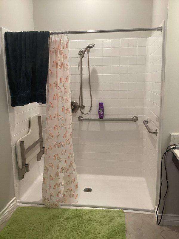 Responded to service call for frozen hot water shower lines that sustained damage over winter months. Conducted thorough assessment of accessible bathroom shower installation with white subway tile walls and dual grab bar safety features. Evaluated extent of freeze damage to hot water supply lines serving shower fixture with handheld chrome showerhead on adjustable sliding bar. 

Determined that proper winterization and insulation protection will require fiberglass wrap installation around vulnerable water lines. Assessment confirmed that scope of work necessitates partial disassembly of shower components to access supply lines behind tile walls. Project will involve careful removal and reinstallation of shower fixtures, potential reorientation of showerhead mounting system, and strategic placement of insulation materials to prevent future freeze events. Documented existing bathroom configuration including accessibility features such as wall-mounted grab bars and fold-down shower seat 