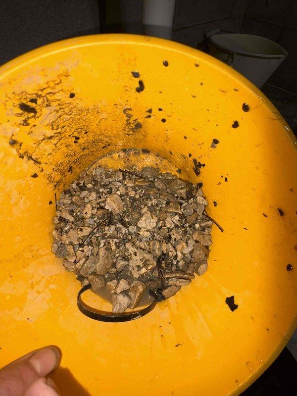 Responded to service call for failed sump pump system that was two years old. Upon arrival, found significant water accumulation on basement floor indicating pump failure. Removed malfunctioning sump pump unit from basin and discovered heavy sediment, gravel, and debris buildup that had compromised the pump's operation and led to premature failure. Cleared debris from pump basin, cleaned discharge piping system, and installed replacement pump unit. Tested new installation for proper float operation and verified adequate discharge flow through existing PVC piping. System restored to full operational capacity with basement floor water issue resolved.