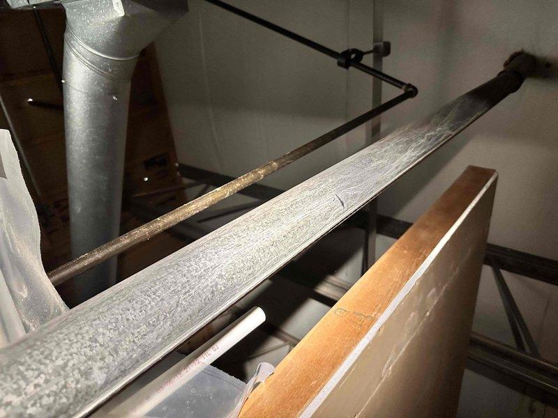 Responded to water leak originating from a 3/4-inch pipe in the attic utility area. Upon inspection, identified active leak causing water damage to carpet below HVAC equipment, with visible moisture staining and discoloration present on flooring surface. Assessed pipe condition and surrounding wooden structural components in attic space. Documented existing water damage patterns on carpet beneath unit, noting irregular staining consistent with ongoing leak from overhead plumbing. Captured photographic documentation of affected areas including pipe location, ductwork proximity, and extent of water infiltration to flooring materials for service records.