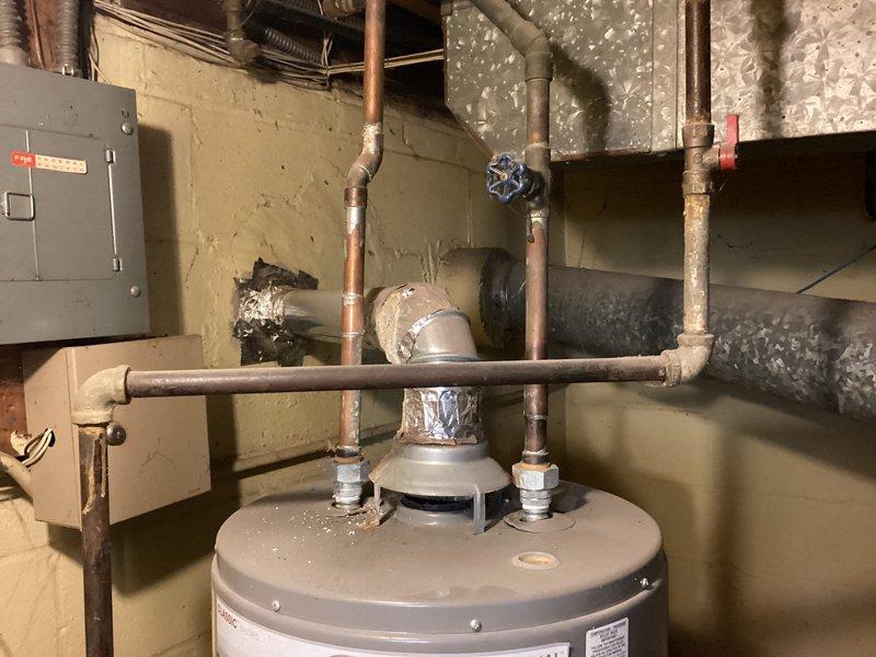 Conducted comprehensive HVAC system evaluation for 30-year-old furnace and air conditioning system replacement estimate. Assessed existing outdoor condenser unit showing significant weathering, surface deterioration, and debris accumulation, along with aging copper refrigerant lines and electrical conduit connections. Documented basement mechanical room infrastructure including water heater, copper plumbing network, electrical panel, and available utility space for new equipment installation. Provided replacement recommendations for both heating and cooling systems due to age and operational concerns, and evaluated feasibility of additional plumbing work requested by homeowner.