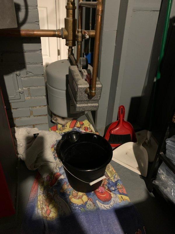Responded to service call for water dripping from boiler pressure gauge. Upon inspection, identified leak at pressure relief valve connection point that worsened when outdoor water spigot was in use, indicating pressure fluctuation issue. Placed collection bucket beneath leak point to prevent water damage and assessed system for proper pressure regulation and expansion tank function.