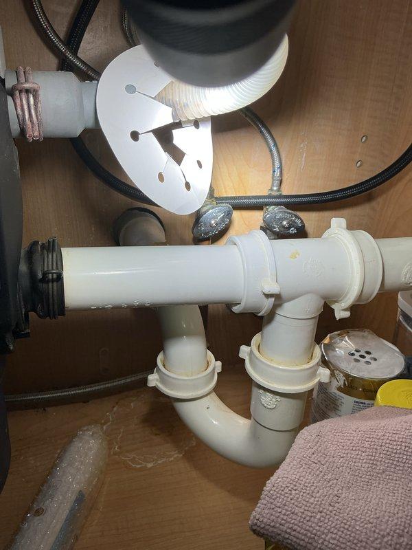 Completed plumbing membership inspection including thorough examination of under-sink plumbing assembly and HVAC utility connections. Verified proper operation of P-trap, supply lines, shut-off valves, and drainage system; confirmed all PVC connections and fittings were secure with no visible leaks. Inspected copper refrigerant lines and flexible ductwork in mechanical room area, noting normal oxidation on copper piping consistent with system age and all components functioning within normal parameters.