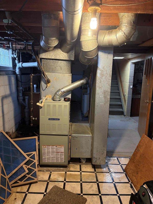 Completed HVAC system assessment for furnace replacement estimate in residential basement mechanical room. Existing furnace system evaluated with non-operational air conditioning unit, documented current equipment configuration including ductwork layout, electrical connections, and ventilation components to provide comprehensive replacement recommendations for single-unit system upgrade.